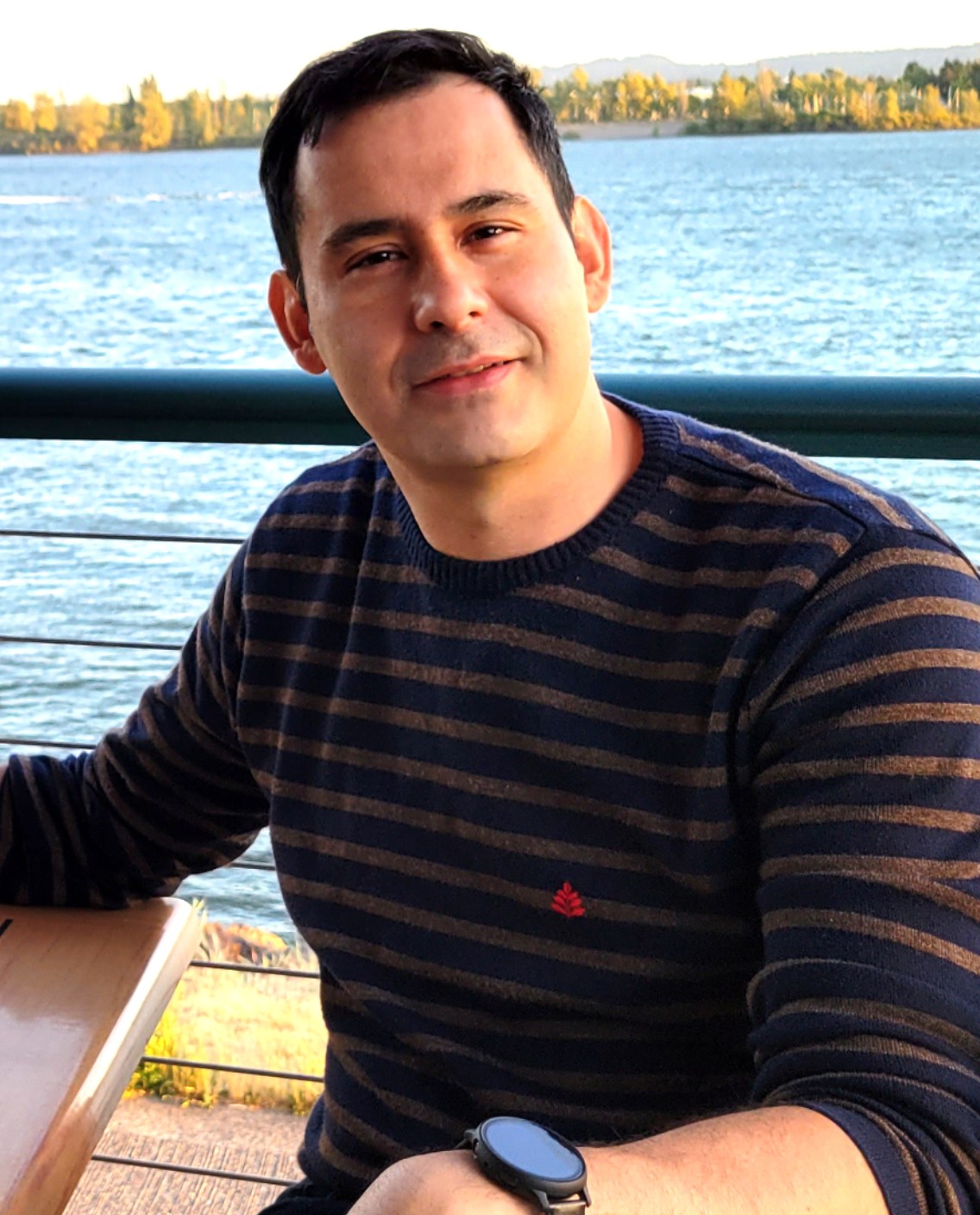 JC, the operator who built the tracker, at a waterfront table in the late-afternoon light.
